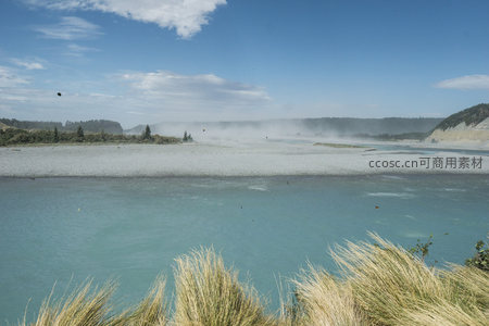 河畔草丛迎风，远山薄雾朦胧