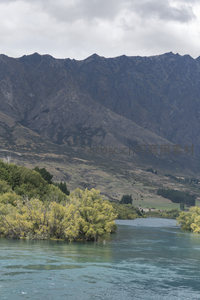 山峦环抱碧水，绿树点缀河岸