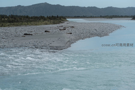 激流拍打石岸，远山如黛映水间