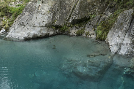 岩壁环抱幽潭，澄澈碧水如镜倒影山色