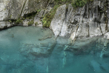 深潭碧水映岩壁，层叠纹理诉说地质故事