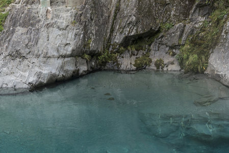 碧水深潭映岩壁，苔藓点缀自然美