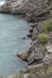 碧水轻抚岩岸枝条垂挂岸边