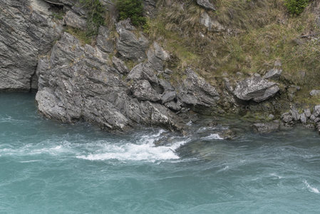 湍流撞石生白沫，河岸岩丛显野趣