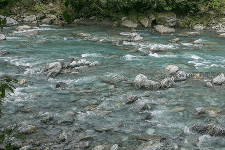 清澈溪流穿石而过，水花飞溅显自然之力