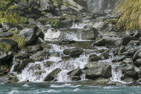 山涧溪流冲击岩石溅起白色水花