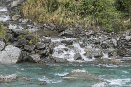 山涧瀑布冲刷嶙峋怪石，水声潺潺入耳