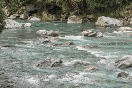 湍急河水绕巨石，浪花翻滚如诗如画