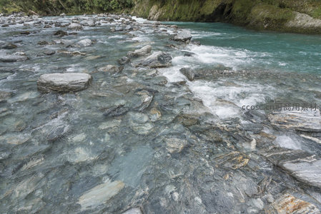 激流碎石间，水纹映天光