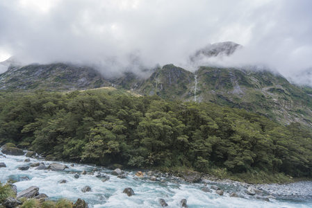 云雾缭绕山峦间，碧水奔腾穿林过