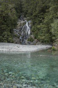 山涧瀑布倾泻入清澈溪流