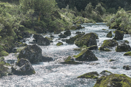 阳光下溪流穿石而过泛白浪
