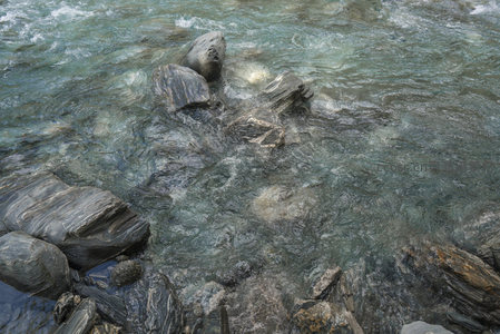 湍急溪流冲刷着深色岩石形成漩涡