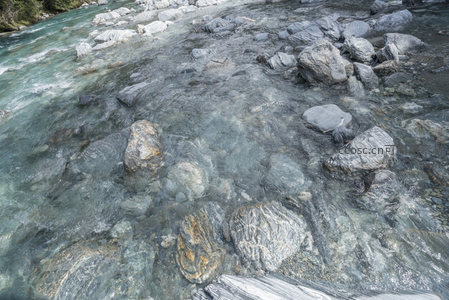 浅水河床中大小不一的圆润石块清晰可见