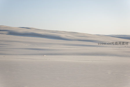 连绵起伏的沙丘在晴空下延伸至天际