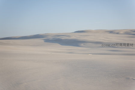 广袤沙丘在晴空下延绵起伏