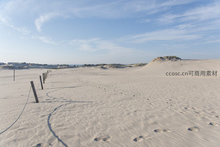 沙滩足迹与木桩围栏的宁静海岸线