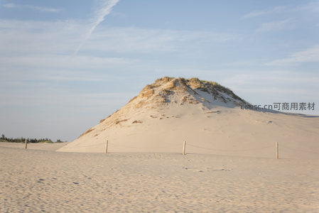 孤峰沙丘矗立蓝天之下