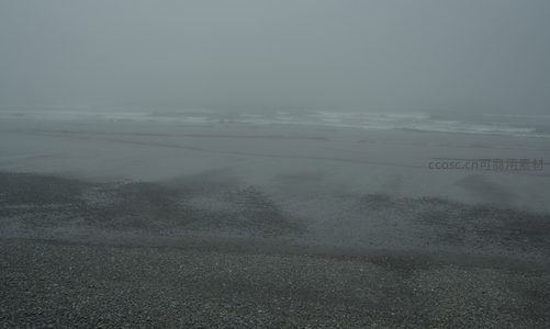 雾霭朦胧，海浪轻吻湿沙滩