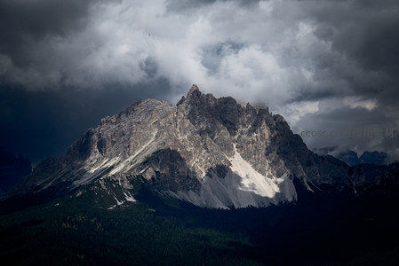 乌云笼罩的巍峨山峰，岩石嶙峋气势磅礴