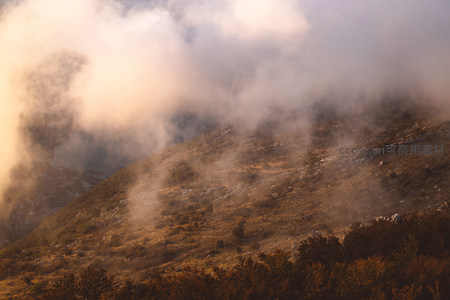 雾霭山峦：晨光穿透云雾洒向山坡