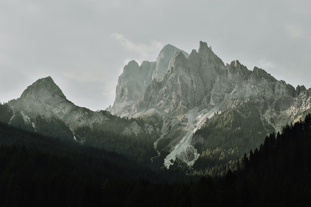 阴云笼罩的苍翠山谷，远山巍峨如沉默巨人