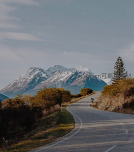 星空下的蜿蜒山路与雪山远景
