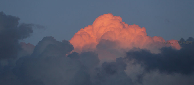 火烧云峰耸入天，橙红云团似熔岩