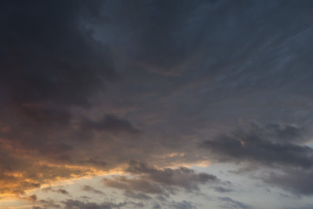 暗云翻涌藏霞光，黄昏天幕如画卷