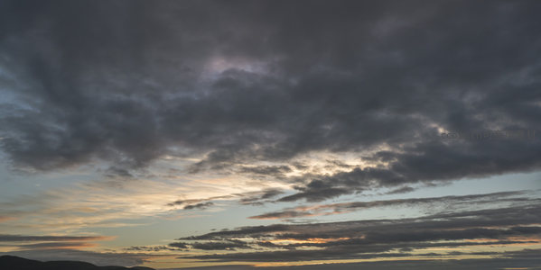 乌云压顶透金边，山峦剪影映霞天