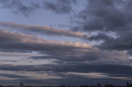 城市上空，流云翻涌染暮色