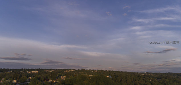 傍晚云层下的郊区住宅与森林景观