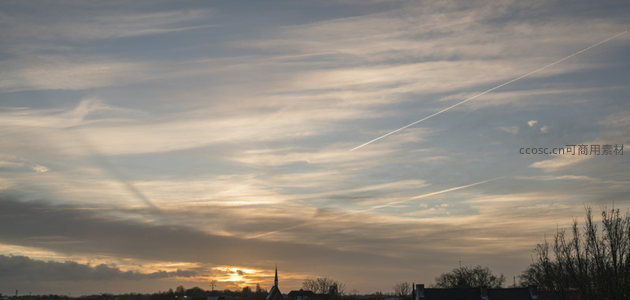 城市天际线上的晚霞与飞机尾迹