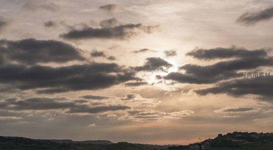山峦之上云层翻涌映衬夕阳余晖