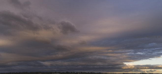 云涛汹涌覆天际，夕照穿云映林梢