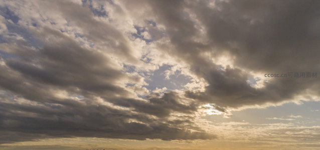 厚重云团裂隙间，阳光倾泻如金纱