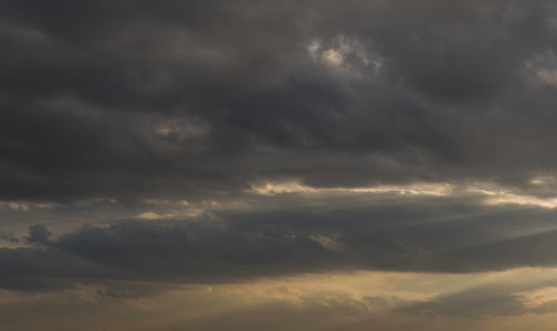 厚重云层缝隙中透出的金色光束