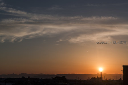 薄雾轻纱般的云朵飘过城市上空，夕阳余晖温柔