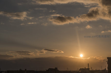 城市上空金色夕阳穿透云层