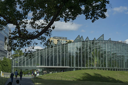 现代玻璃温室建筑与绿意盎然的公园景观