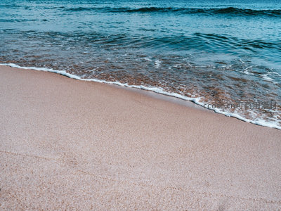 碧蓝海水轻抚粉沙海岸的静谧画面