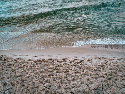 踩满脚印的沙滩与轻柔海浪的午后时光