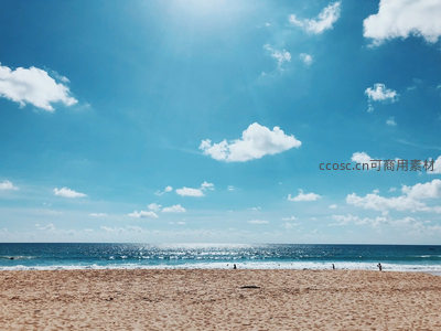 阳光洒满金色沙滩与蔚蓝海面