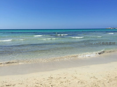 清澈海水轻抚柔软沙滩岸