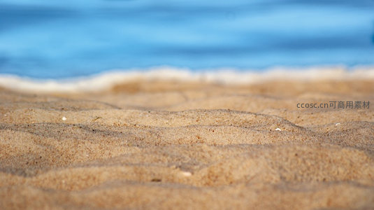 微距镜头下细腻的沙滩纹理与海浪