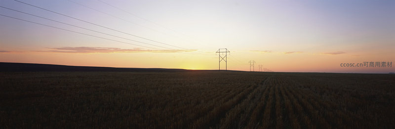 夕阳下的田野与输电塔剪影