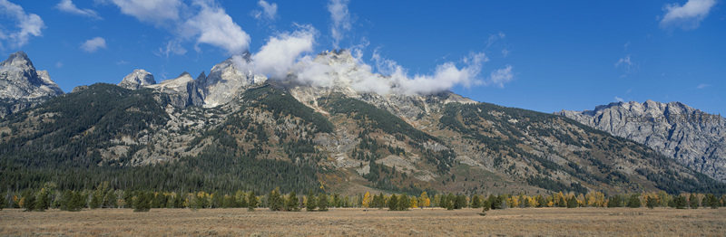 云雾缭绕的壮丽山脉与秋色草原
