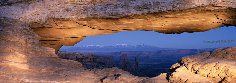 天然拱门框住远山雪峰，暮色温柔降临