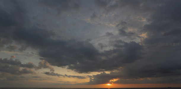 云层缝隙中的落日余晖洒向海面