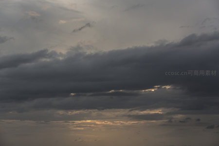 厚重云层间透出的温暖夕阳光芒